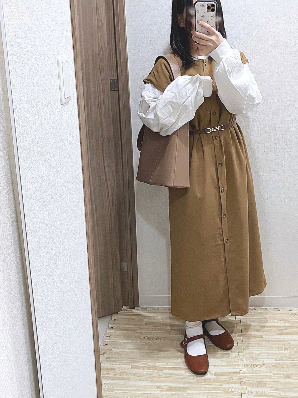 ホワイト系のTシャツ/カットソー、ベージュ系のワンピース、ブラウン系のパンプスを着用したレディースの春コーディネートの2枚目の写真