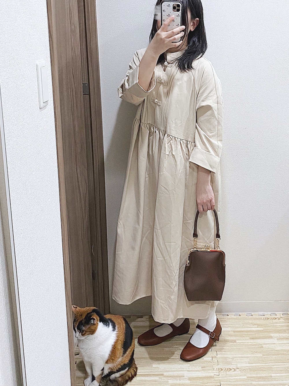 ベージュ系のワンピース、ブラウン系のショルダーバッグ、ブラウン系のパンプスを着用したレディースの春コーディネートの2枚目の写真