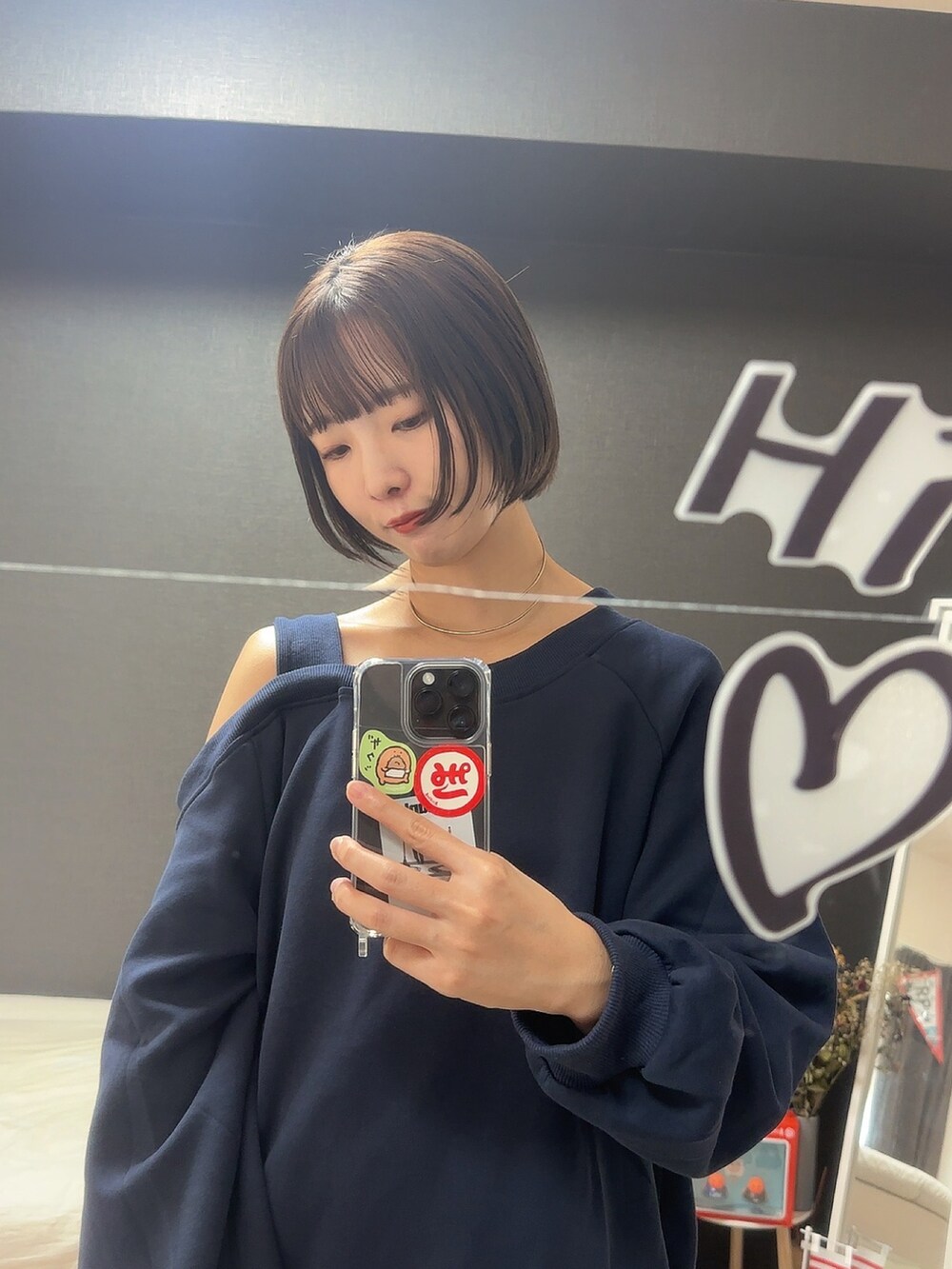 ブルー系のスウェット、ホワイト系のスカート、ブラウン系のメガネを着用したレディースの秋コーディネートの2枚目の写真