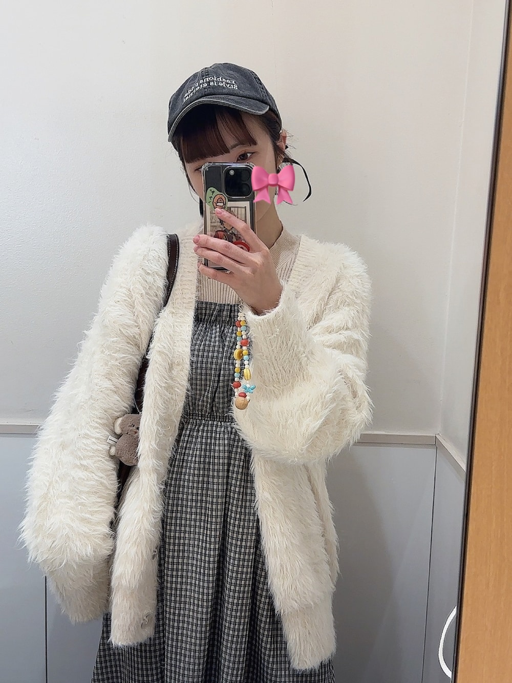 ホワイト系のカーディガン/ボレロ、ブラック系のワンピース、ホワイト系のニット/セーターを着用したレディースの春コーディネートの2枚目の写真