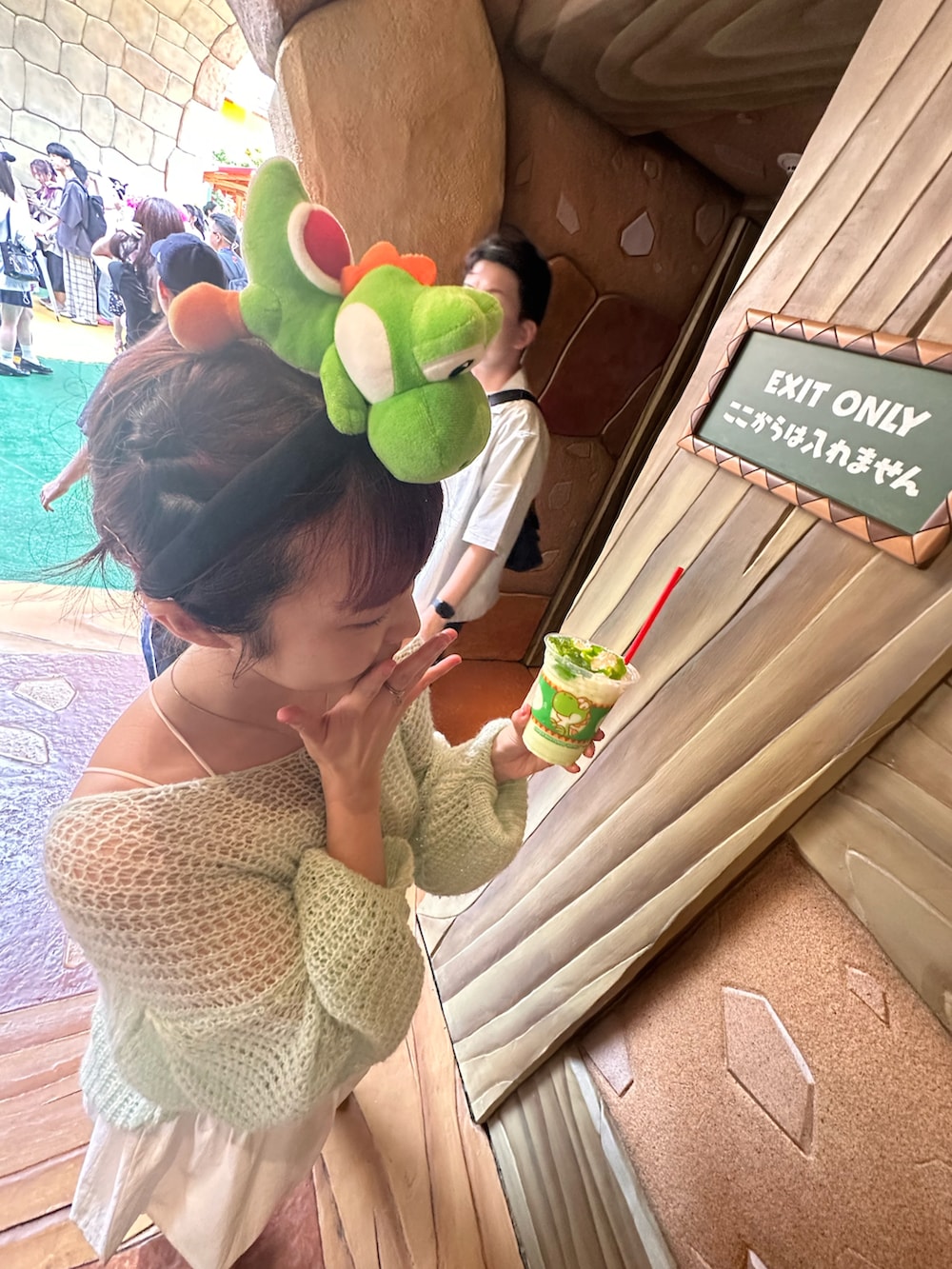 ブラック系のブーツ、グリーン系のニット/セーター、ホワイト系のスカートを着用したレディースの夏コーディネートの3枚目の写真