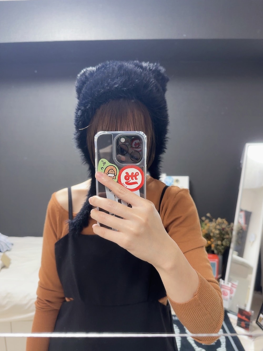 ブラック系のワンピース、オレンジ系のニット/セーター、ブラック系の帽子を着用したレディースの秋コーディネートの2枚目の写真