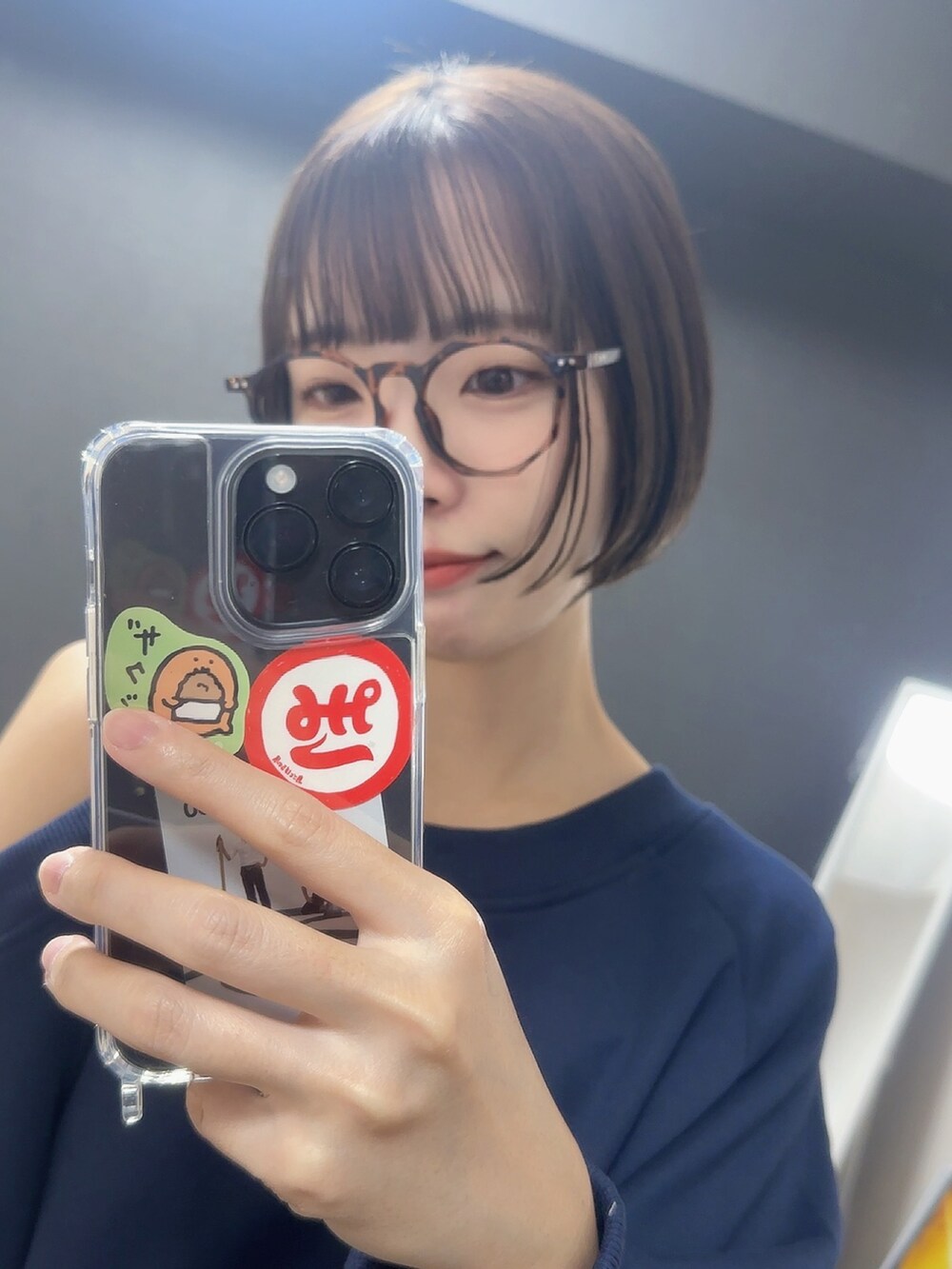 ブルー系のスウェット、ホワイト系のスカート、ブラウン系のメガネを着用したレディースの秋コーディネートの3枚目の写真