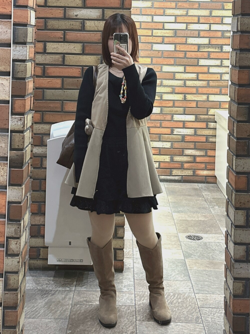 ブラック系のニット/セーター、ブラック系のスカート、ブラック系のキャミソールを着用したレディースの春コーディネートの2枚目の写真