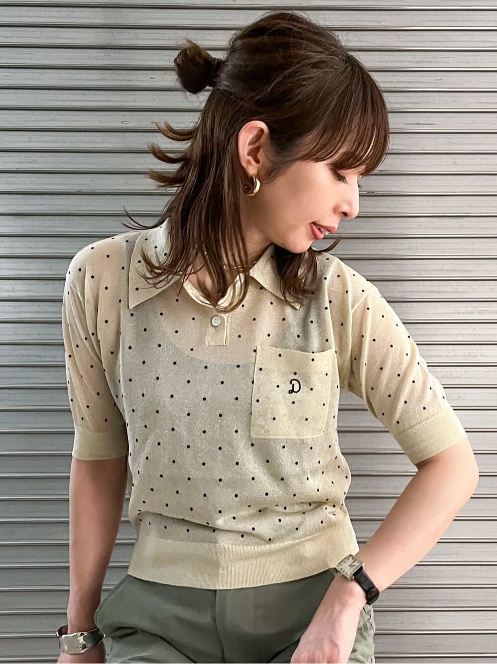ベージュ系のポロシャツ、ゴールド系のピアス（両耳用）を着用したレディースの夏コーディネートの5枚目の写真