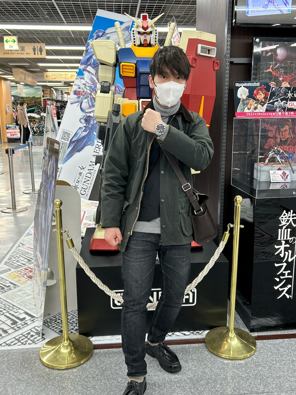 グリーン系のミリタリージャケット、ブラウン系のショルダーバッグ、ブラック系のモカシン/デッキシューズを着用したメンズの冬コーディネートの2枚目の写真