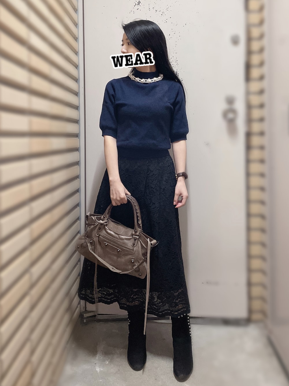 ブルー系のトップス、ブラック系のスカート、ブラック系のブーツを着用したレディースの秋コーディネートの2枚目の写真