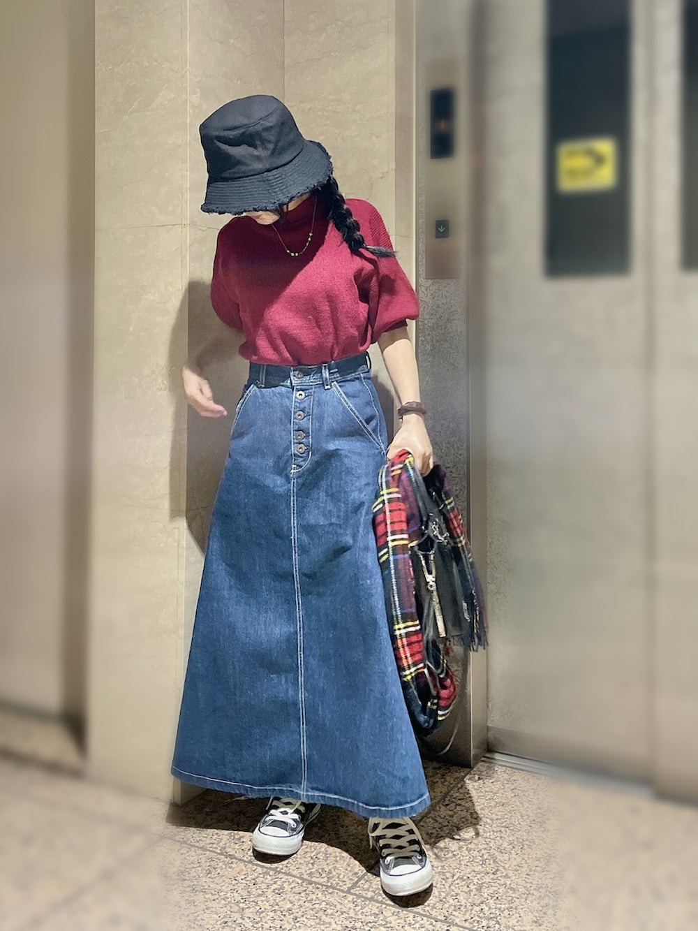 レッド系のニット/セーター、ブルー系のデニムスカート、その他のハンドバッグを着用したレディースの秋コーディネートの3枚目の写真