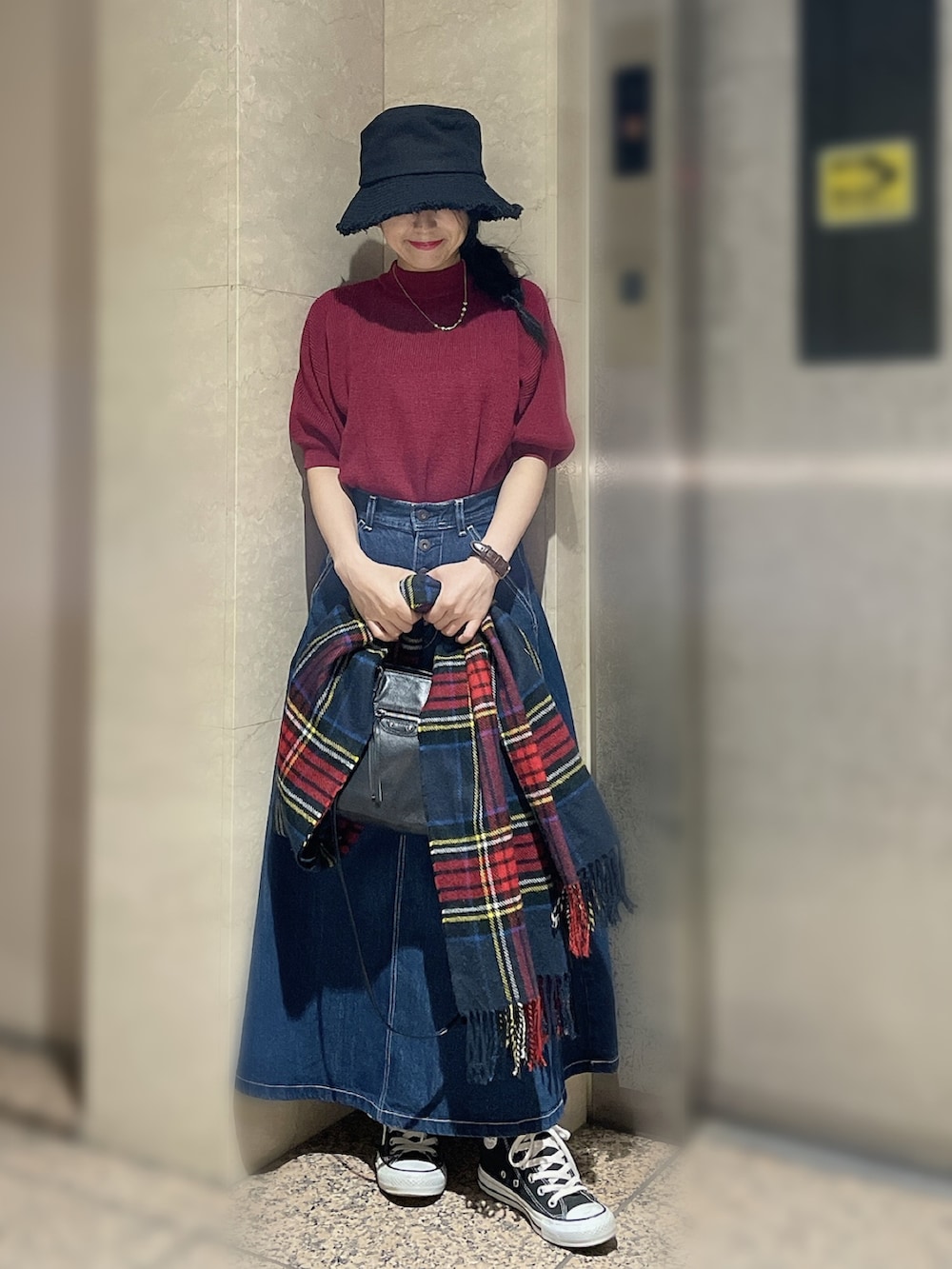 レッド系のニット/セーター、ブルー系のデニムスカート、その他のハンドバッグを着用したレディースの秋コーディネートの2枚目の写真