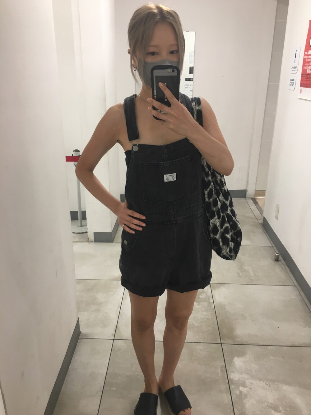 ブラック系のサロペット/オーバーオール、グレー系のトートバッグ、ブラック系のチューブトップを着用したレディースの秋コーディネートの2枚目の写真