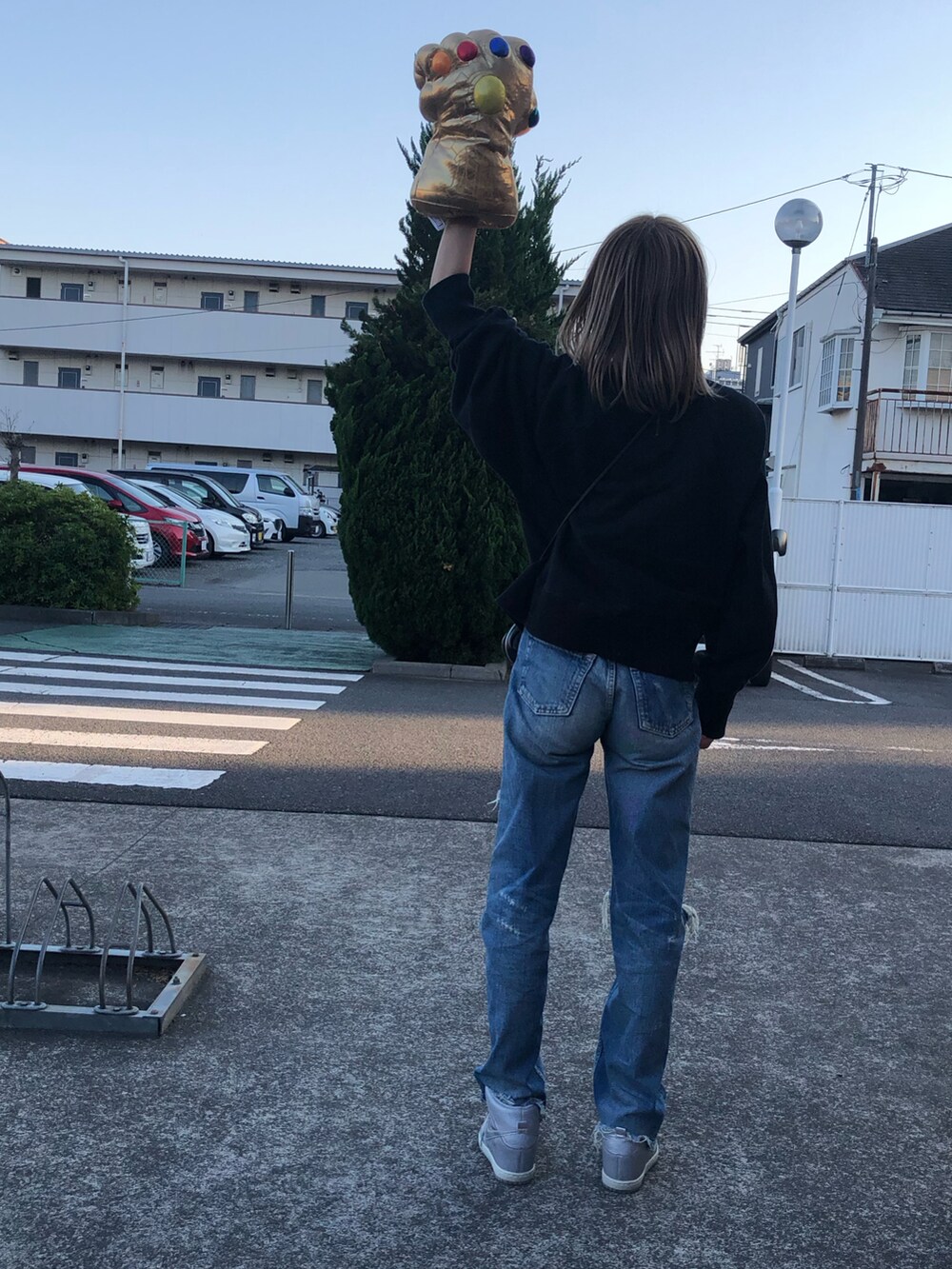 ブルー系のデニムパンツ、ブラック系のショルダーバッグ、ブラック系のスウェットを着用したレディースの春コーディネートの5枚目の写真