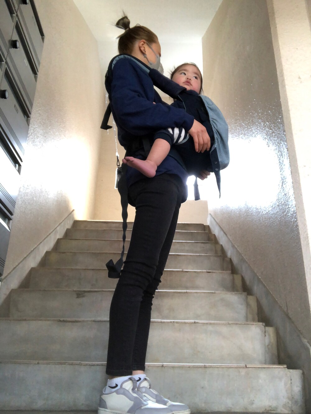 ブラック系のデニムパンツ、グレー系のスニーカー、シルバー系のバッグを着用したレディースの春コーディネートの2枚目の写真