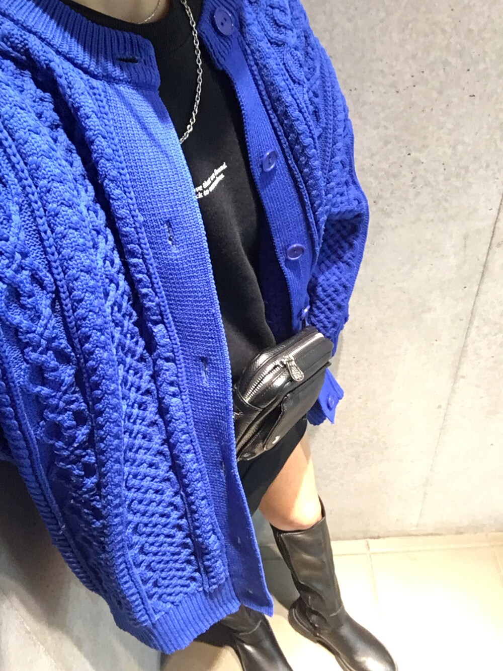 ブラック系のブーツ、ブルー系のニット/セーター、ブラック系のショルダーバッグを着用したレディースの冬コーディネートの5枚目の写真