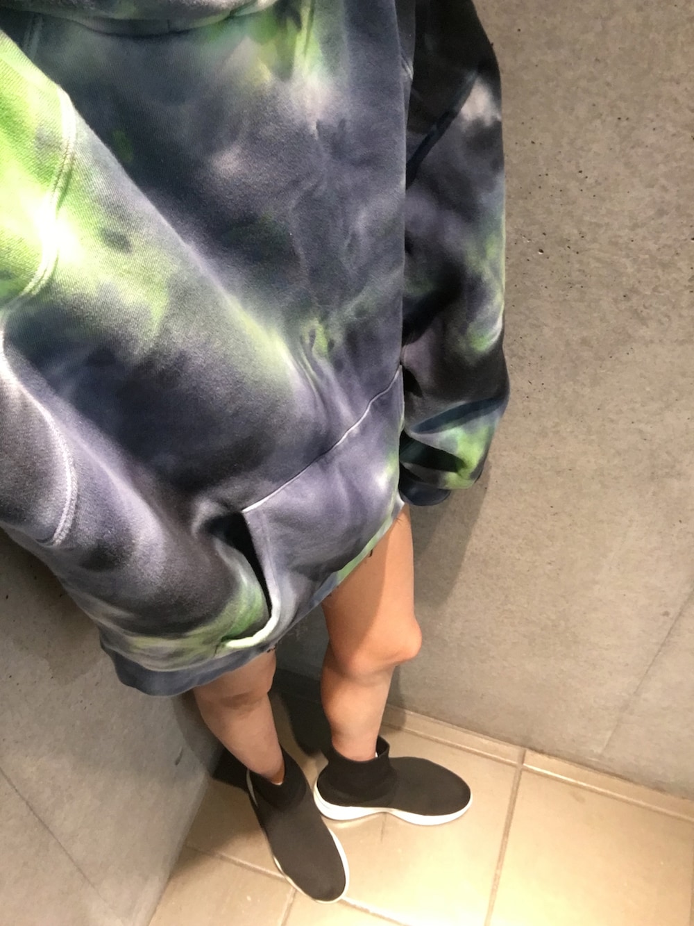 ブラック系のスニーカー、ブルー系のパーカー、ブラック系のデニムパンツを着用したレディースの秋コーディネートの5枚目の写真