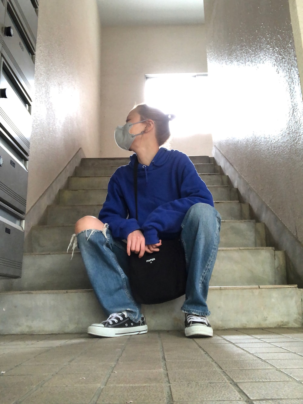 ブルー系のデニムパンツ、ブラック系のショルダーバッグ、ブラック系のスニーカーを着用したレディースの春コーディネートの5枚目の写真