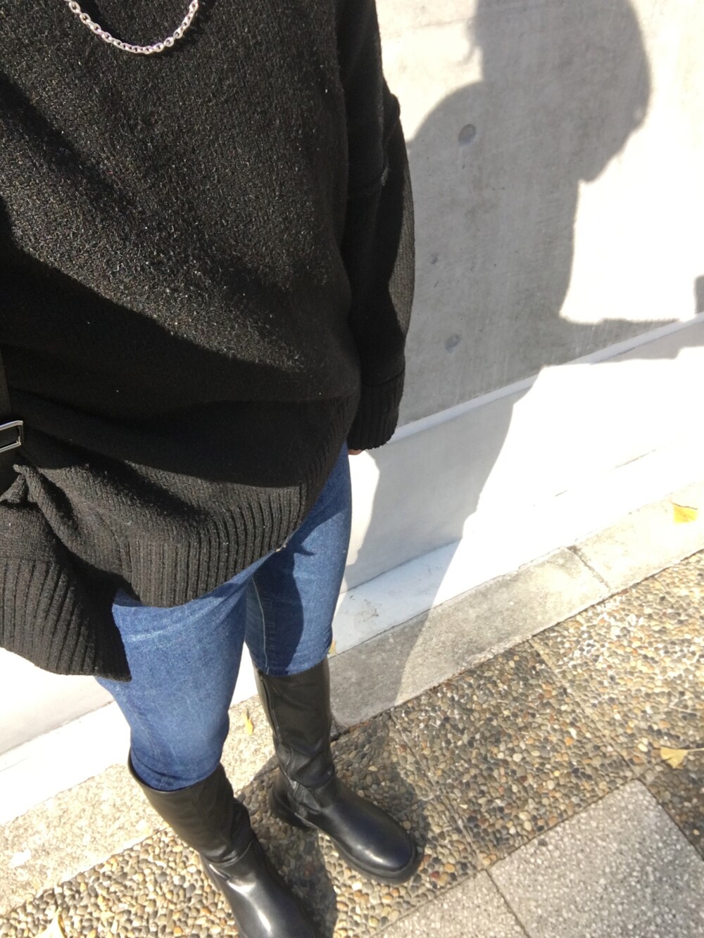 ブラック系のブーツ、ブラック系のニット/セーター、ブラック系のショルダーバッグを着用したレディースの冬コーディネートの3枚目の写真