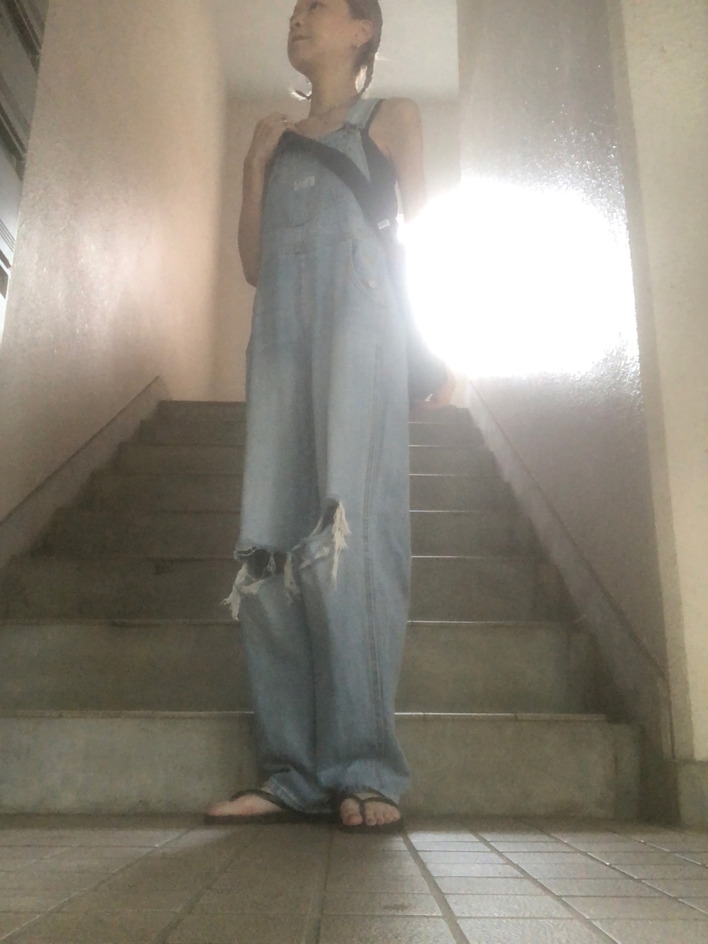 ブルー系のサロペット/オーバーオール、ブラック系のサンダル、ブラック系のタンクトップを着用したレディースの秋コーディネートの2枚目の写真