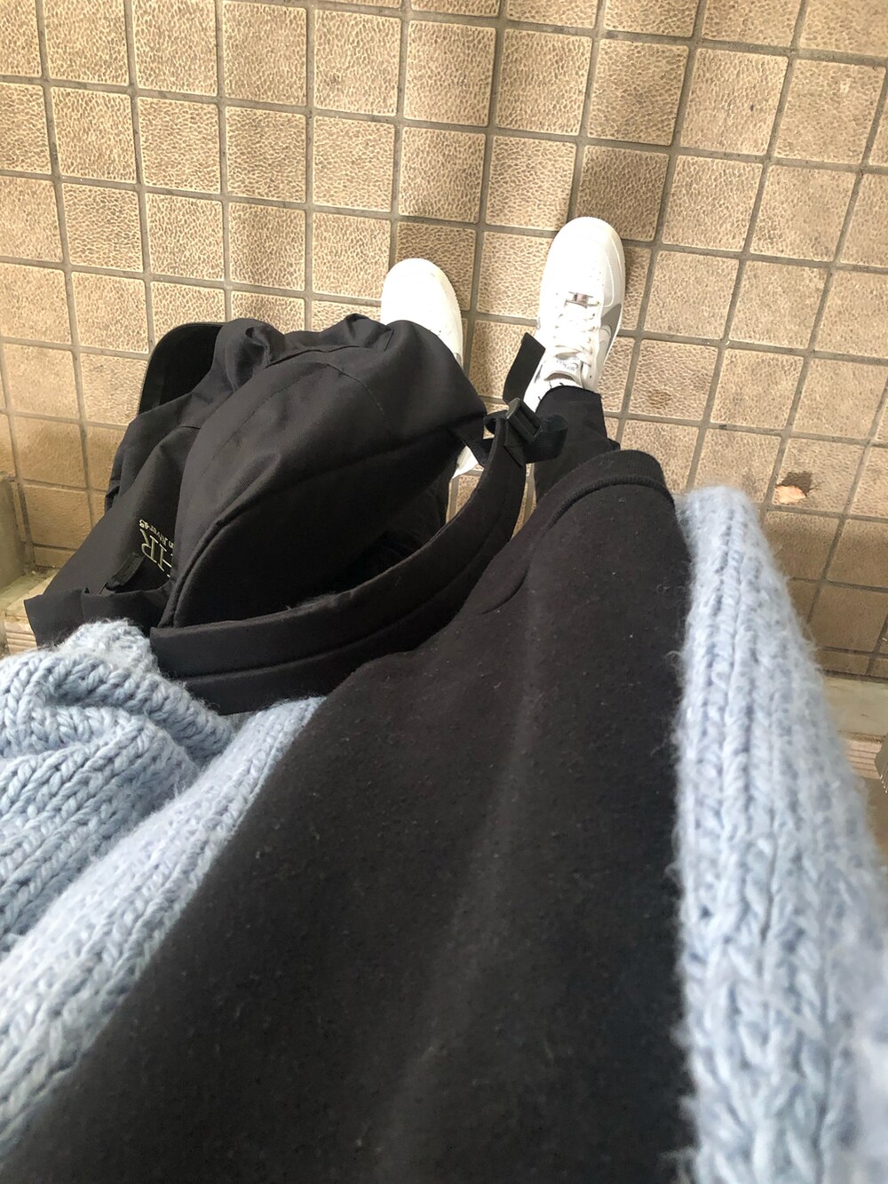 レッド系のショルダーバッグ、ホワイト系のスニーカー、ブラック系のデニムパンツを着用したレディースの秋コーディネートの5枚目の写真