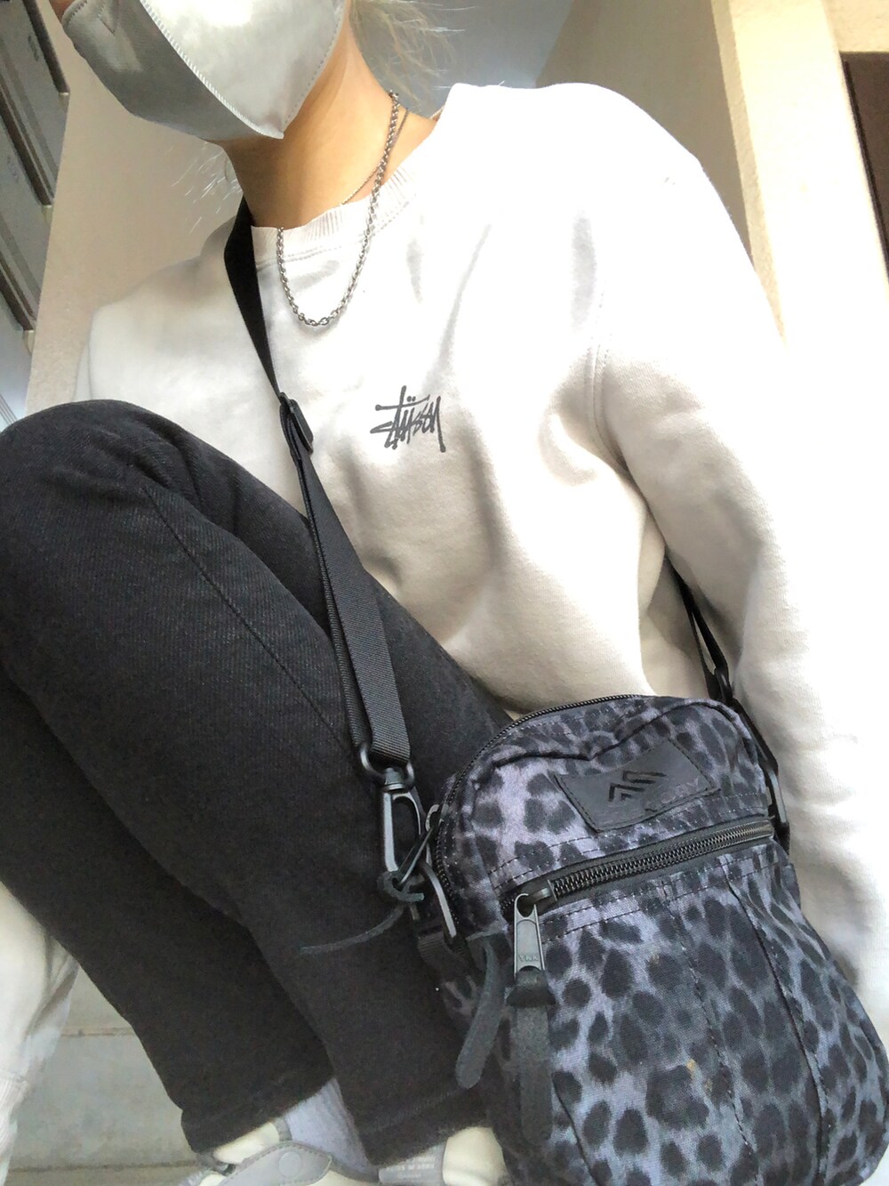 ブルー系のデニムパンツ、グレー系のスニーカー、ブラック系のショルダーバッグを着用したレディースの春コーディネートの5枚目の写真