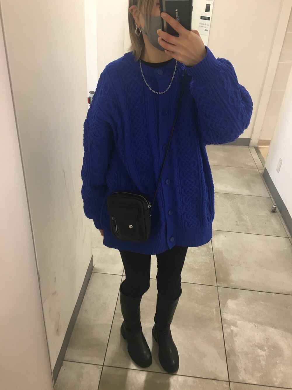 ブラック系のブーツ、ブルー系のニット/セーター、ブラック系のデニムパンツを着用したレディースの冬コーディネートの4枚目の写真