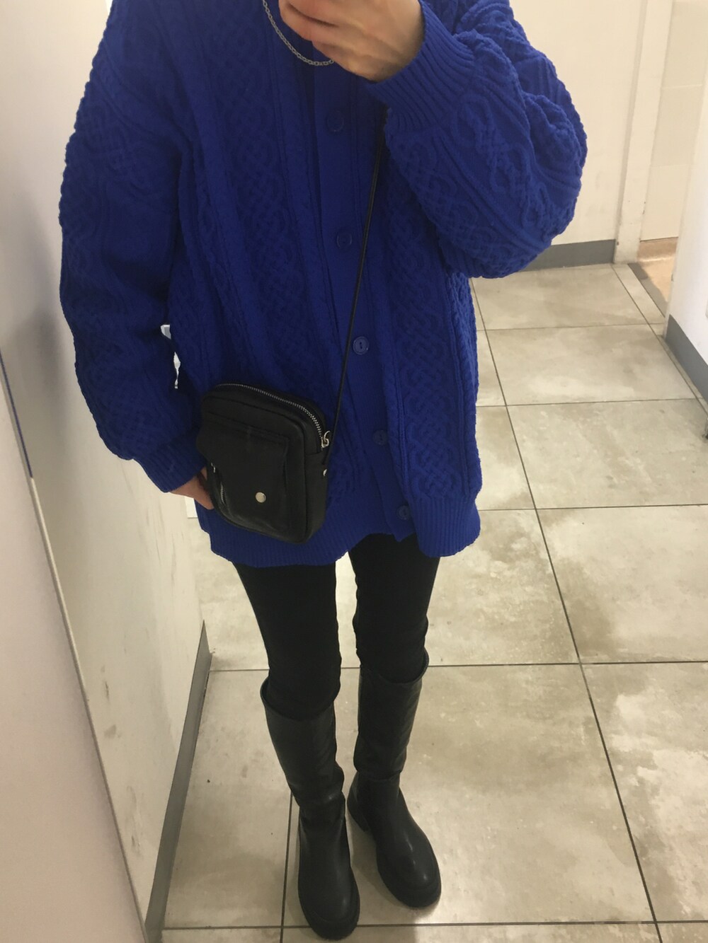 ブラック系のブーツ、ブルー系のニット/セーター、ブラック系のデニムパンツを着用したレディースの冬コーディネートの2枚目の写真