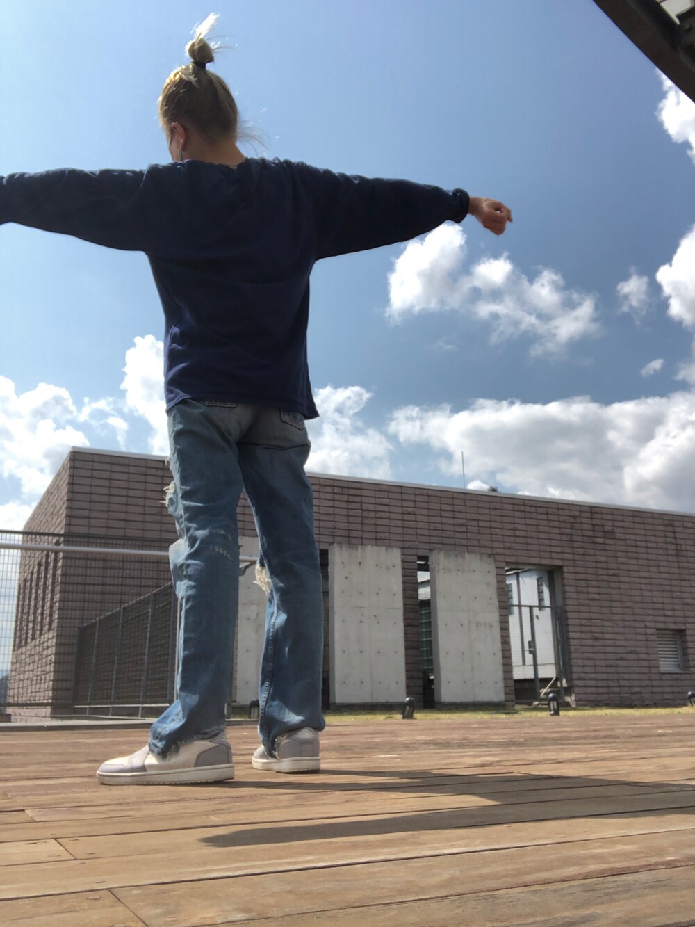 ブルー系のデニムパンツ、グレー系のスニーカー、ブルー系のTシャツ/カットソーを着用したレディースの春コーディネートの3枚目の写真