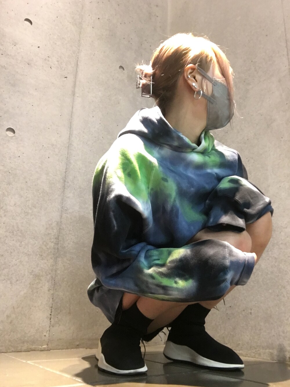 ブラック系のスニーカー、ブルー系のパーカー、ブラック系のデニムパンツを着用したレディースの秋コーディネートの3枚目の写真