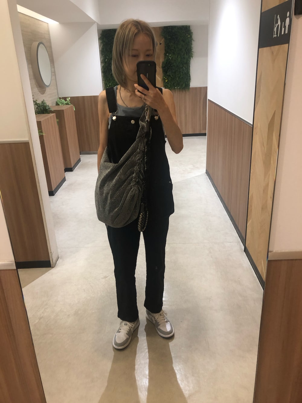 ブラック系のサロペット/オーバーオール、グレー系のスニーカー、シルバー系のリングを着用したレディースの夏コーディネートの3枚目の写真