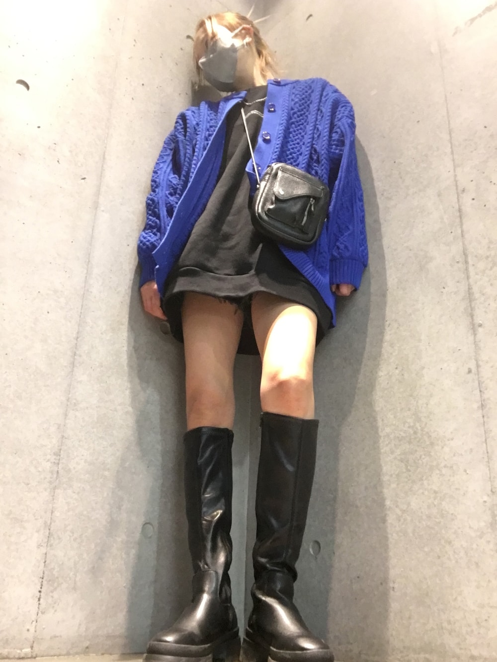 ブラック系のブーツ、ブルー系のニット/セーター、ブラック系のショルダーバッグを着用したレディースの冬コーディネートの3枚目の写真