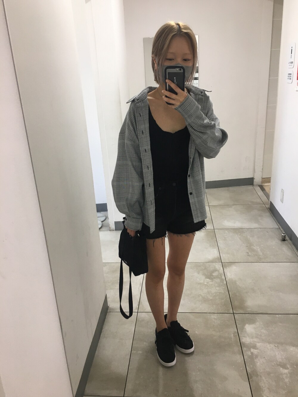 ブラック系のスニーカー、ブラック系のタンクトップ、ブラック系のショルダーバッグを着用したレディースの秋コーディネートの4枚目の写真