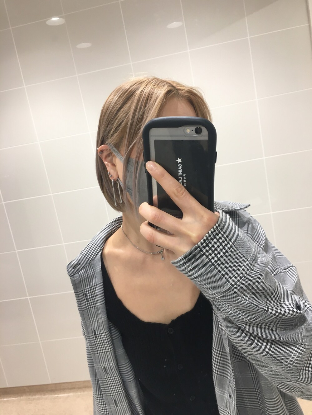 ブラック系のスニーカー、ブラック系のタンクトップ、ブラック系のショルダーバッグを着用したレディースの秋コーディネートの5枚目の写真