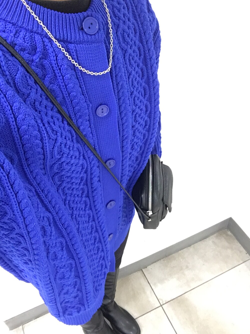 ブラック系のブーツ、ブルー系のニット/セーター、ブラック系のデニムパンツを着用したレディースの冬コーディネートの3枚目の写真