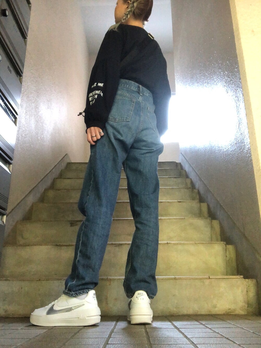 ブルー系のデニムパンツ、ホワイト系のスニーカー、ブルー系のシャツ/ブラウスを着用したレディースの秋コーディネートの4枚目の写真