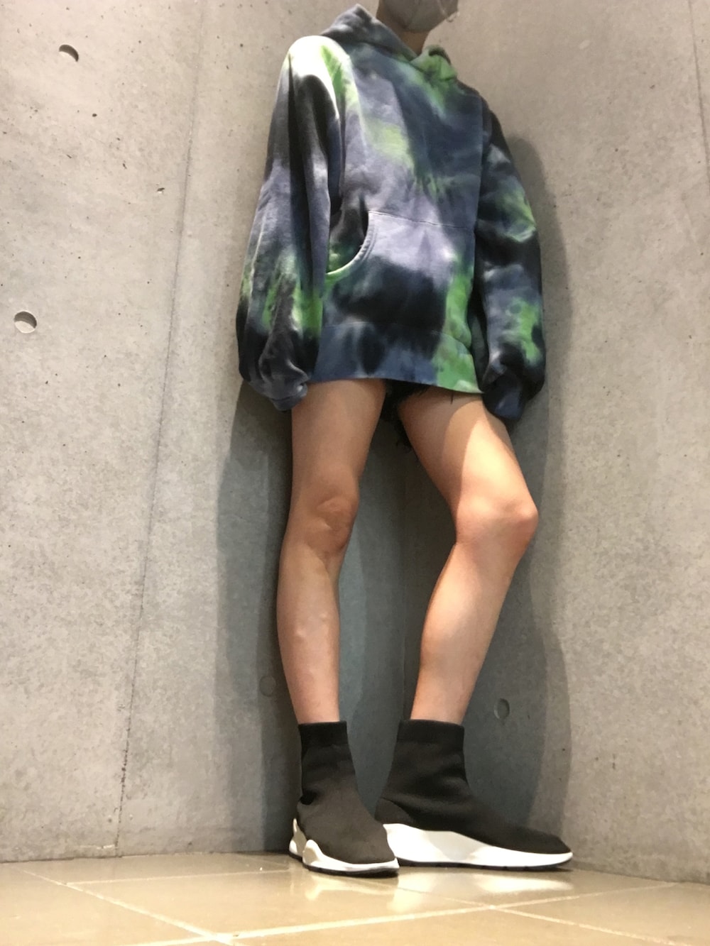 ブラック系のスニーカー、ブルー系のパーカー、ブラック系のデニムパンツを着用したレディースの秋コーディネートの2枚目の写真