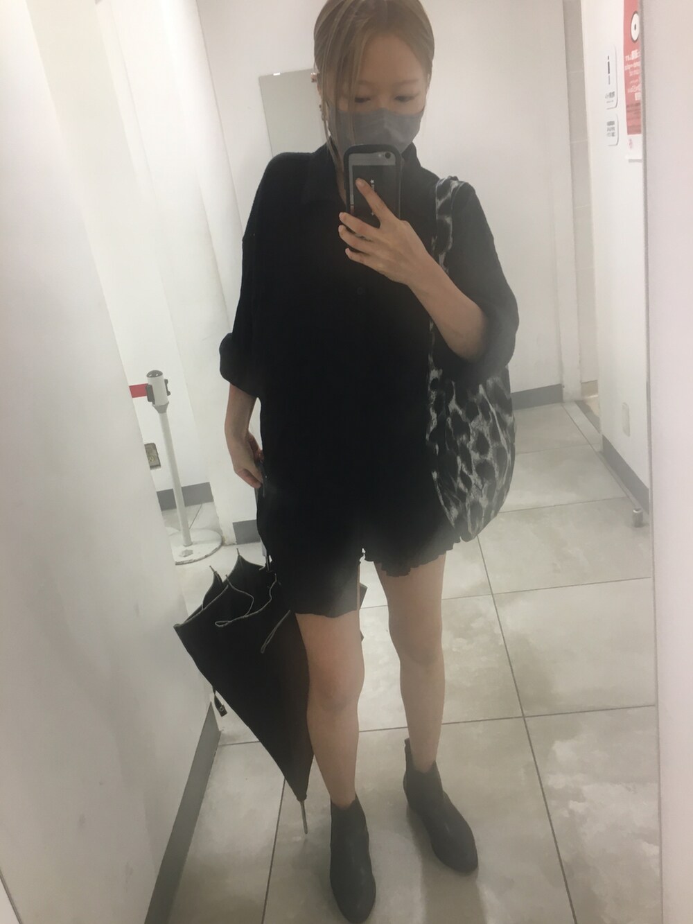 ブラック系のシャツ/ブラウス、ブラック系のブーツ、グレー系のトートバッグを着用したレディースの秋コーディネートの3枚目の写真