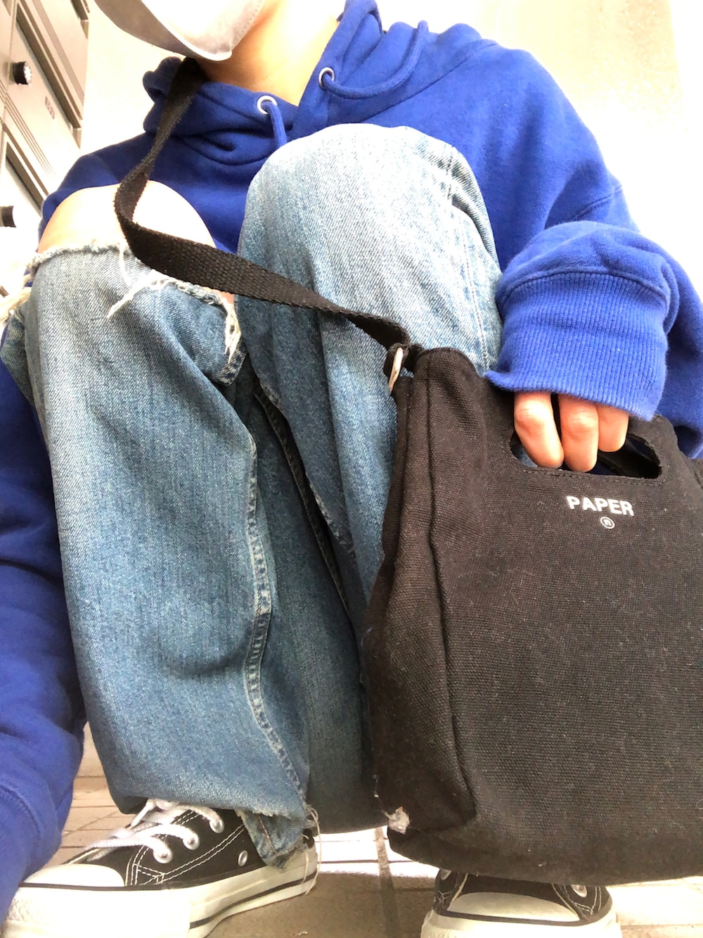 ブルー系のデニムパンツ、ブラック系のショルダーバッグ、ブラック系のスニーカーを着用したレディースの春コーディネートの4枚目の写真