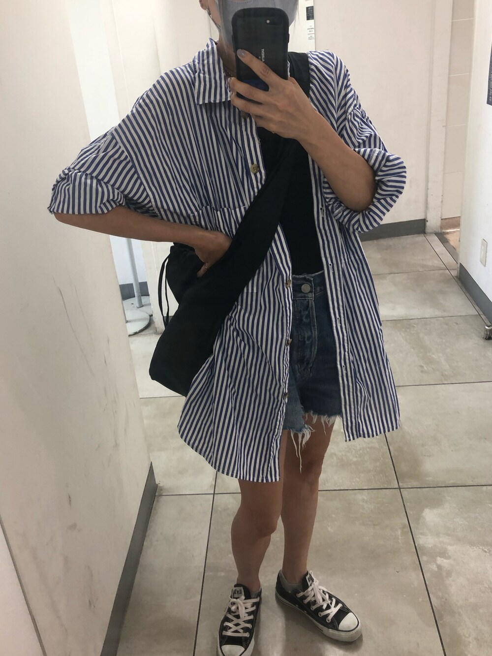 ブラック系のスニーカー、ブルー系のデニムパンツ、ブルー系のシャツ/ブラウスを着用したレディースの夏コーディネートの2枚目の写真