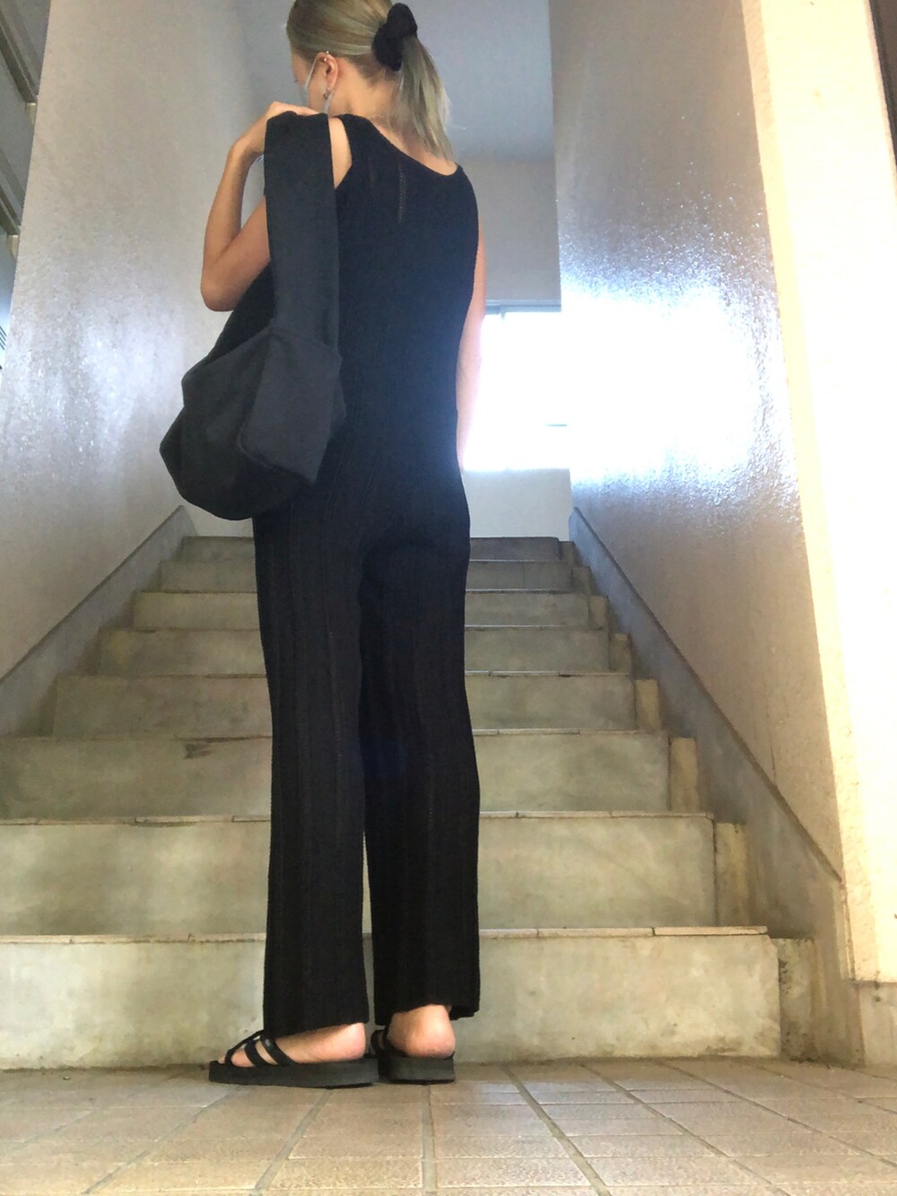 ブラック系のサンダル、ブラック系のサロペット/オーバーオール、ブラック系のショルダーバッグを着用したレディースの秋コーディネートの2枚目の写真