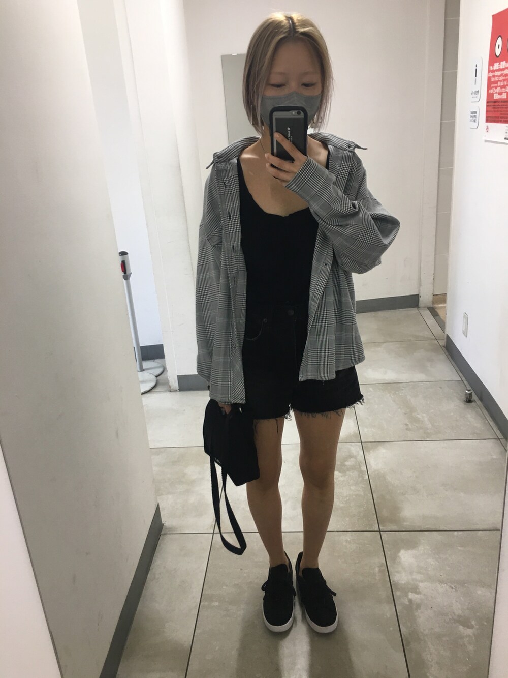 ブラック系のスニーカー、ブラック系のタンクトップ、ブラック系のショルダーバッグを着用したレディースの秋コーディネートの2枚目の写真