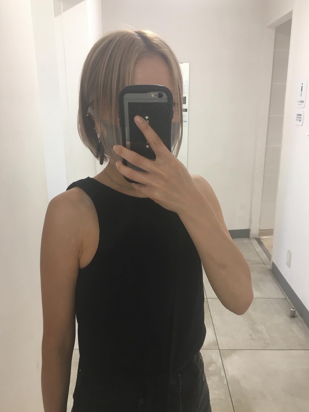 ブラック系のデニムパンツ、ホワイト系のタンクトップ、ゴールド系のサンダルを着用したレディースの秋コーディネートの2枚目の写真