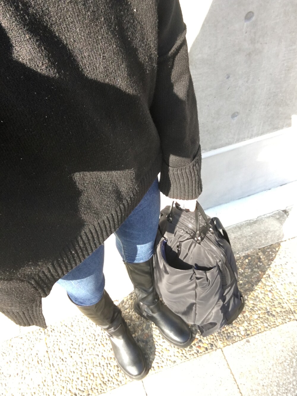 ブラック系のブーツ、ブラック系のニット/セーター、ブラック系のショルダーバッグを着用したレディースの冬コーディネートの4枚目の写真