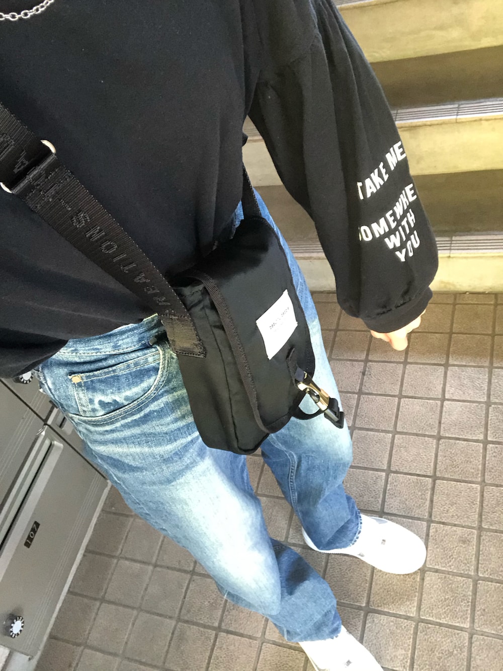 ブルー系のデニムパンツ、ホワイト系のスニーカー、ブルー系のシャツ/ブラウスを着用したレディースの秋コーディネートの5枚目の写真