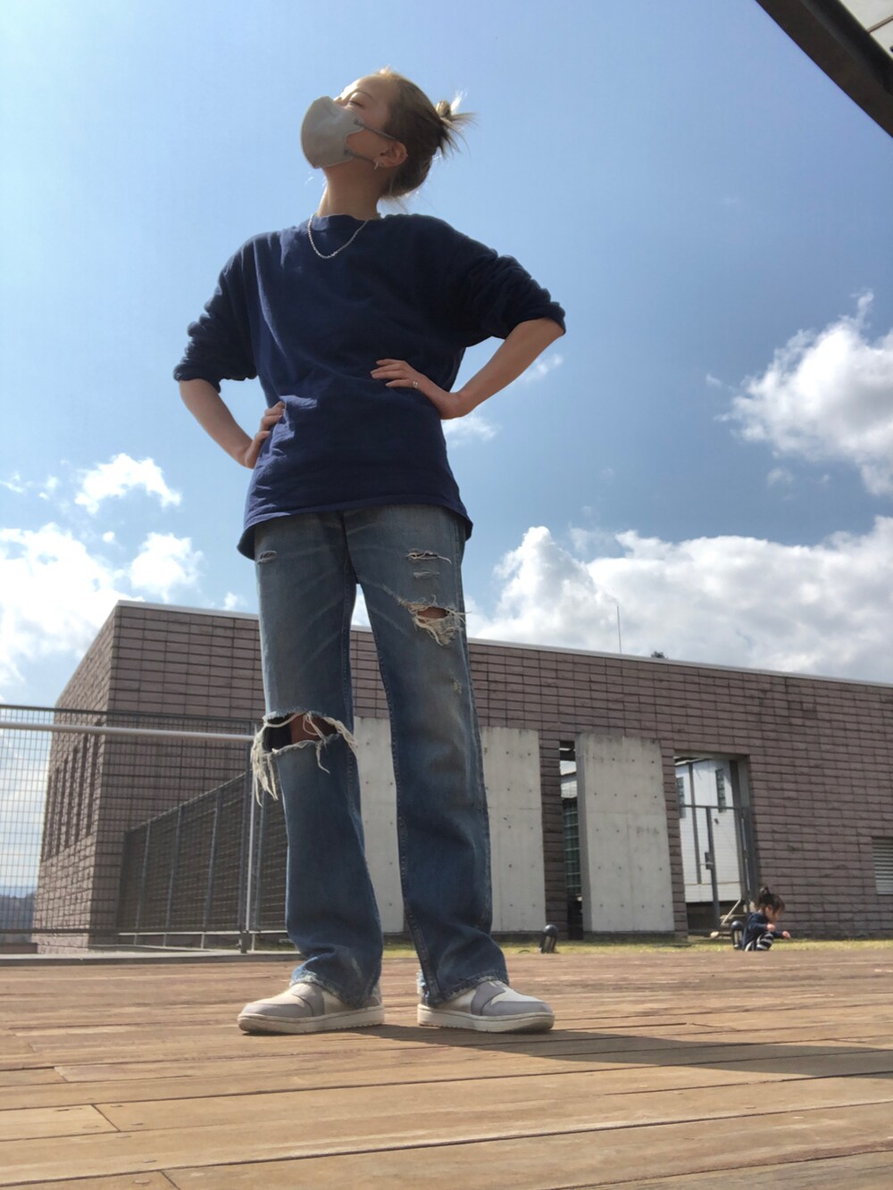 ブルー系のデニムパンツ、グレー系のスニーカー、ブルー系のTシャツ/カットソーを着用したレディースの春コーディネートの2枚目の写真