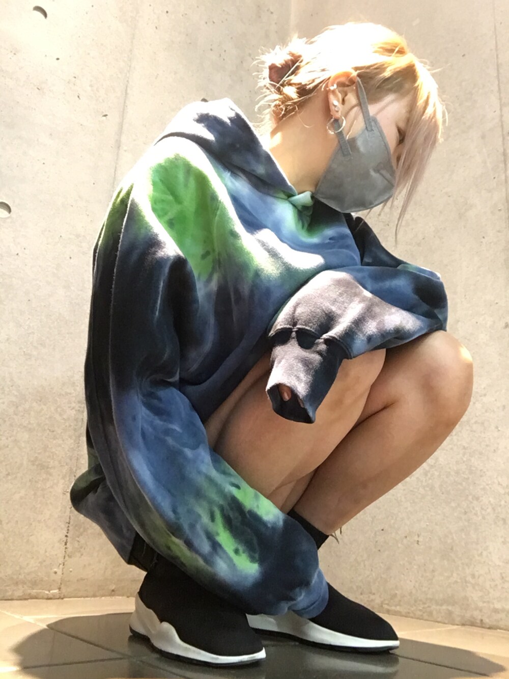 ブラック系のスニーカー、ブルー系のパーカー、ブラック系のデニムパンツを着用したレディースの秋コーディネートの4枚目の写真