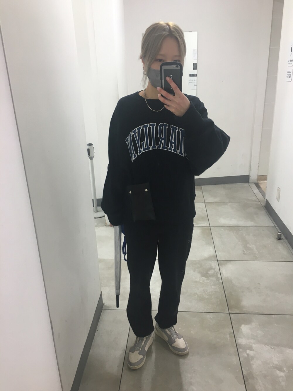 グレー系のスニーカー、ブラック系のスウェット、ブラック系のショルダーバッグを着用したレディースの秋コーディネートの5枚目の写真