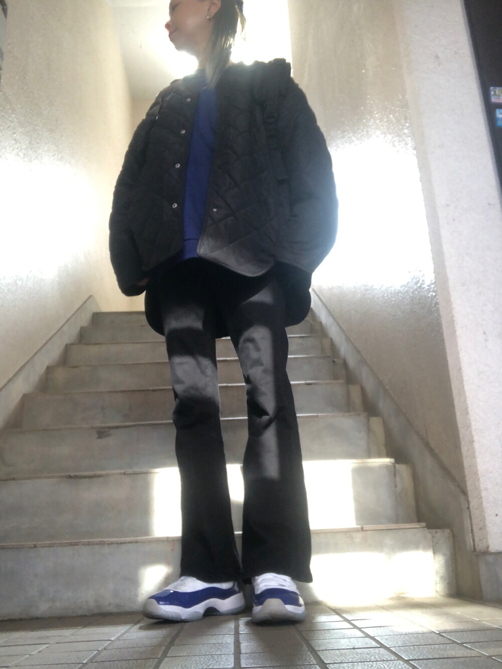 ブラック系のデニムパンツ、ブラック系のブルゾン、レッド系のショルダーバッグを着用したレディースの冬コーディネートの2枚目の写真