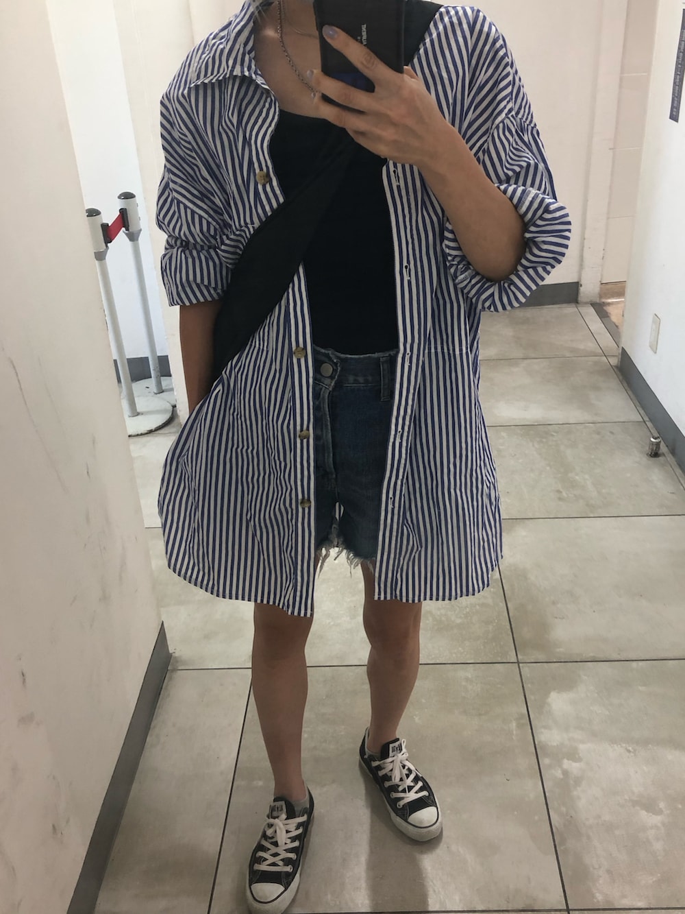 ブラック系のスニーカー、ブルー系のデニムパンツ、ブルー系のシャツ/ブラウスを着用したレディースの夏コーディネートの3枚目の写真