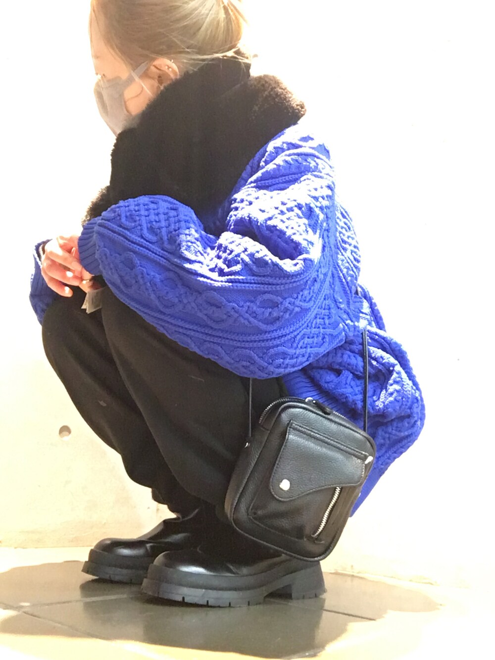 ブルー系のニット/セーター、ブラック系のその他パンツ、ホワイト系のブーツを着用したレディースの冬コーディネートの3枚目の写真