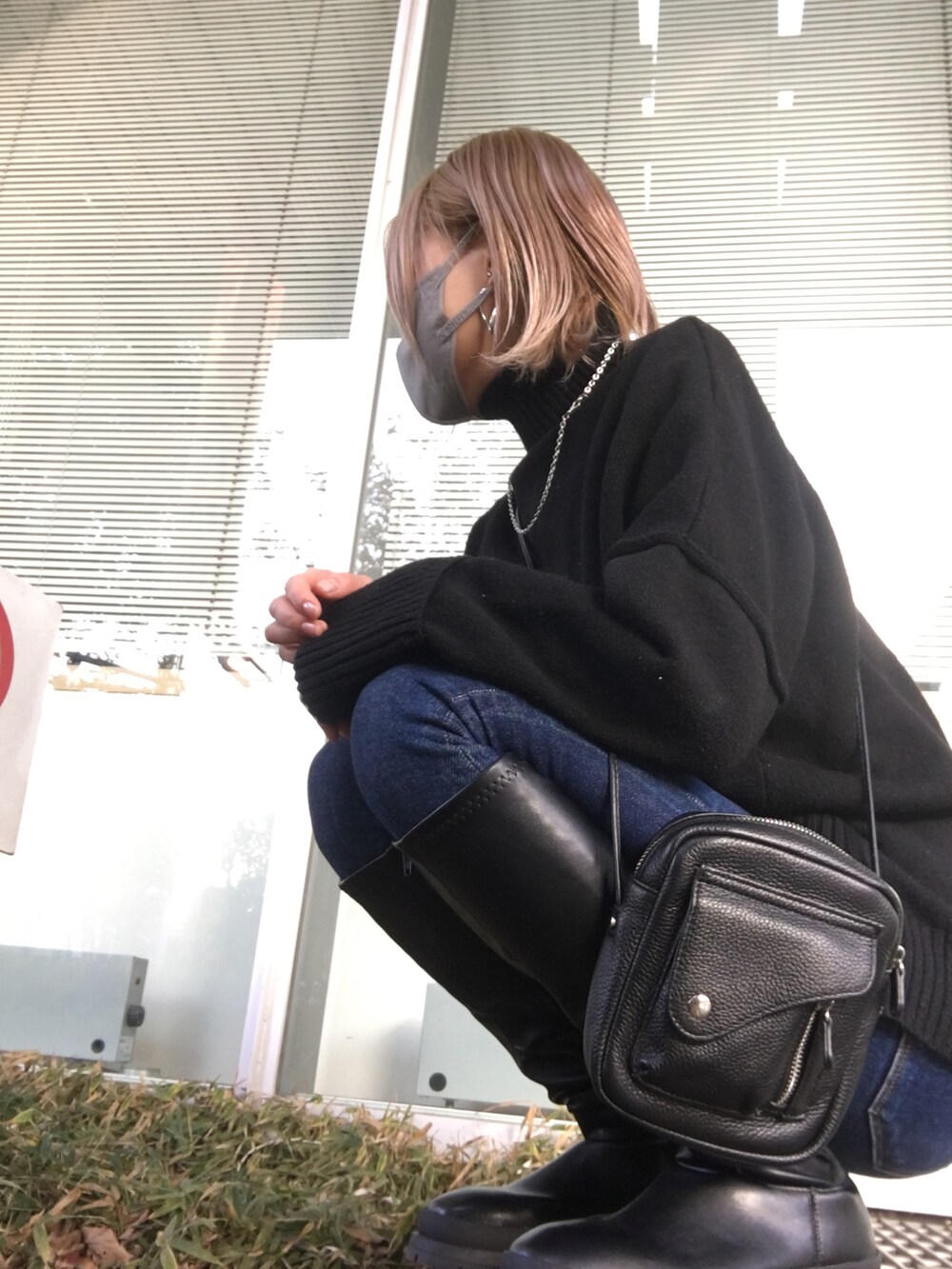 ブラック系のブーツ、ブラック系のニット/セーター、ブラック系のショルダーバッグを着用したレディースの冬コーディネートの2枚目の写真