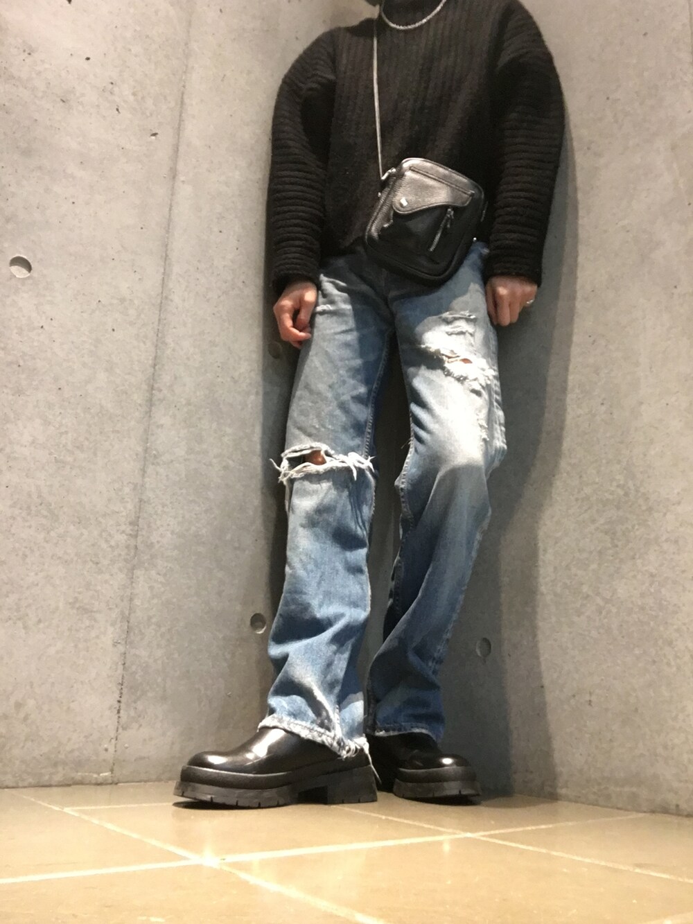 ブラック系のニット/セーター、ブラック系のショルダーバッグ、ホワイト系のブーツを着用したレディースの冬コーディネートの3枚目の写真